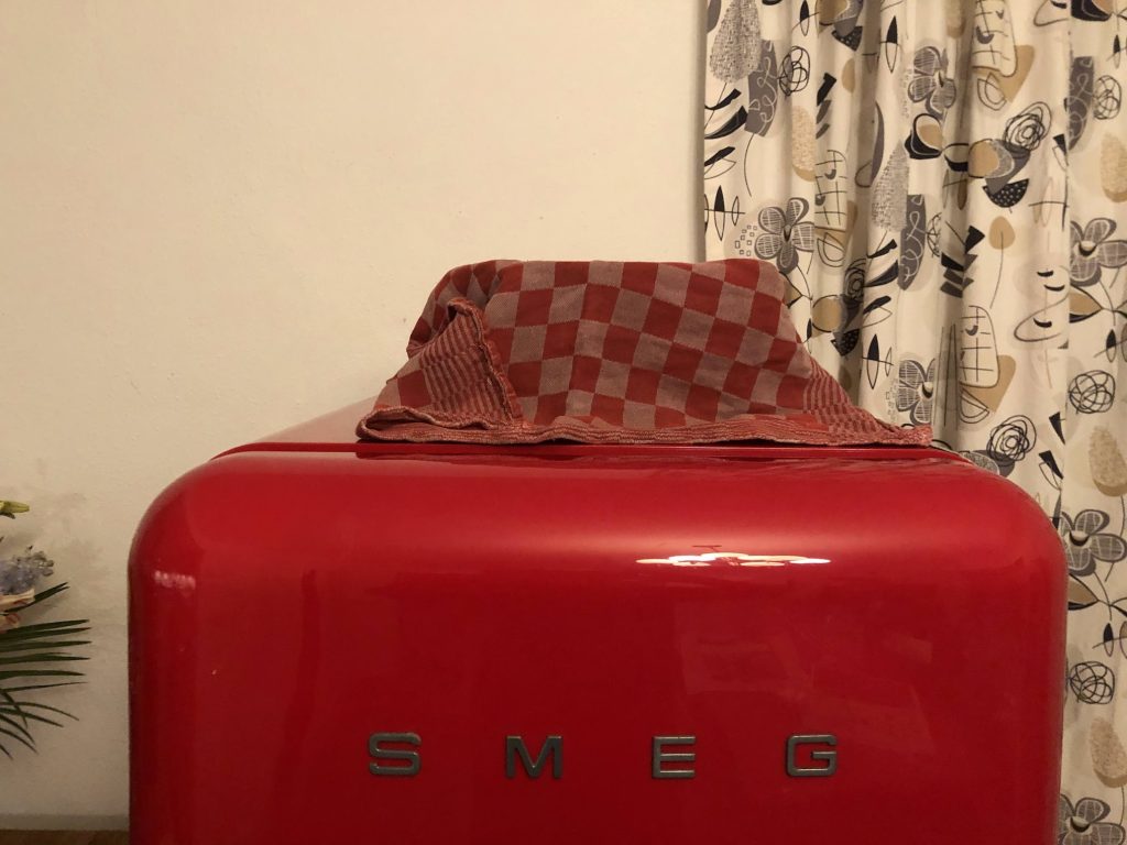 deeg bedekt met een theedoek op de supermooie rode Smeg koelkast.